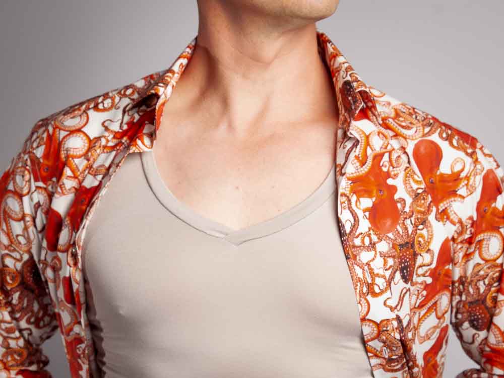 Man wearing a grey undershirt under an orange shirt.