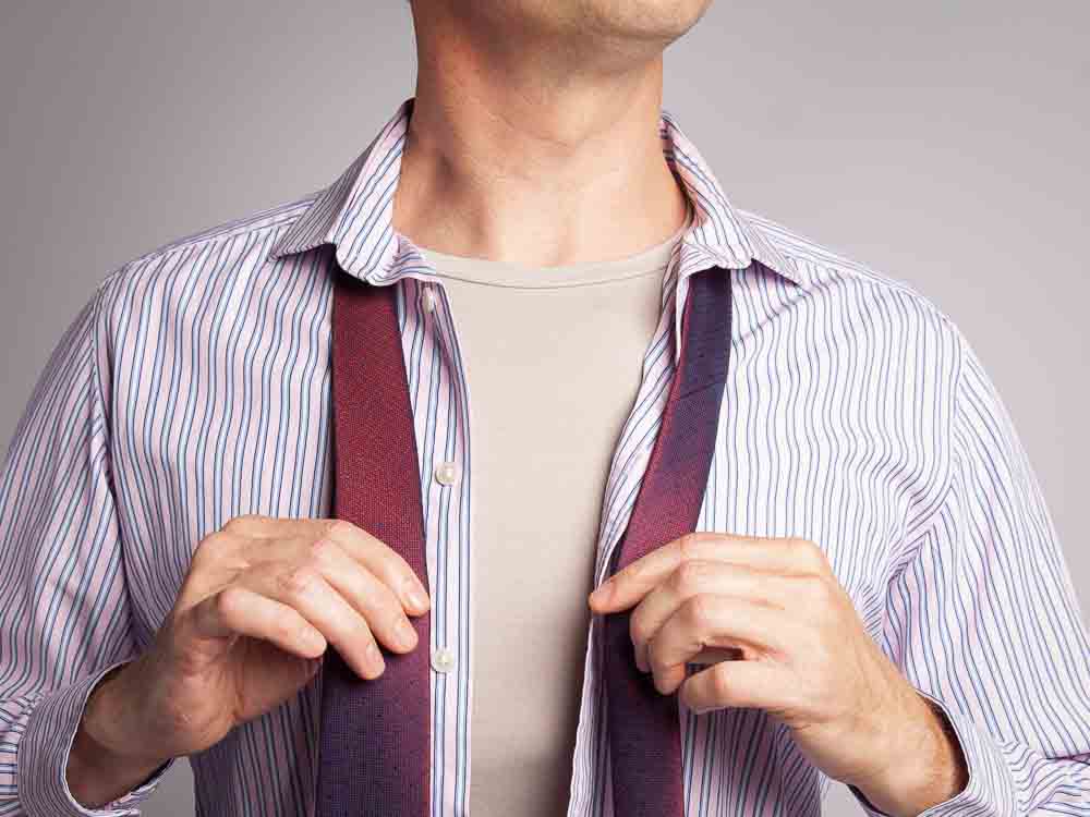 Man wearing a crew neck heather grey undershirt under his shirt and tie