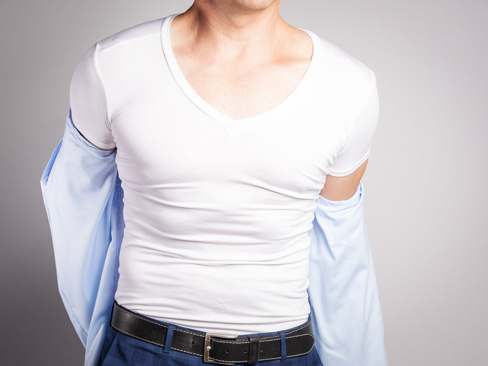 Man taking of shirt to review a white v-neck undershirt 