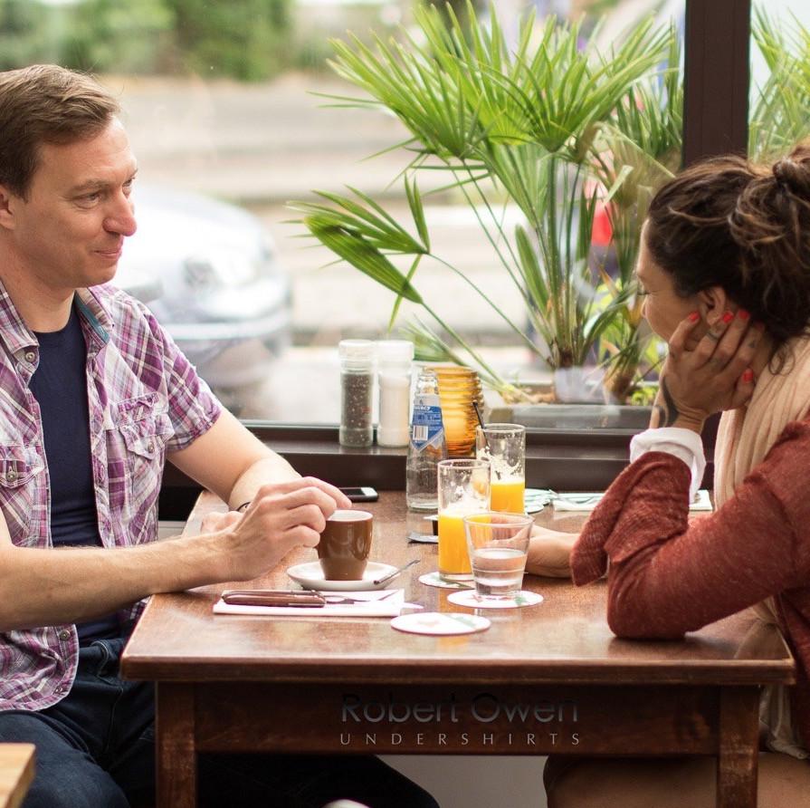 Two people sat at a table in a face with drinks